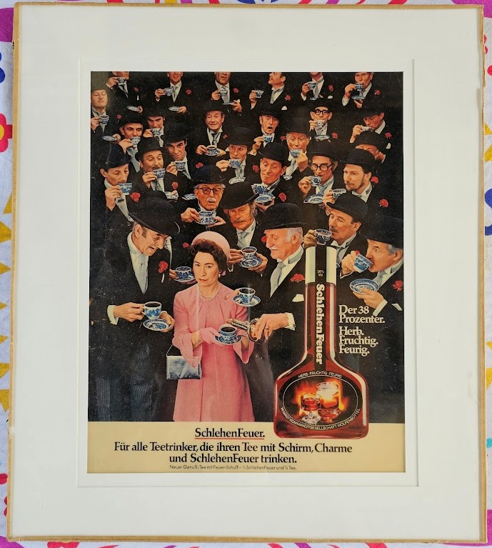 Sneaky sloe gin in tea, Queen lookalike with men in bowler hats for Schlehen Feuer, laminated ad under glass by Michael Joseph